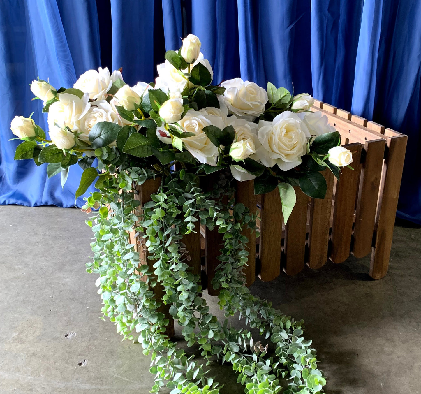 White roses in wooden planter.